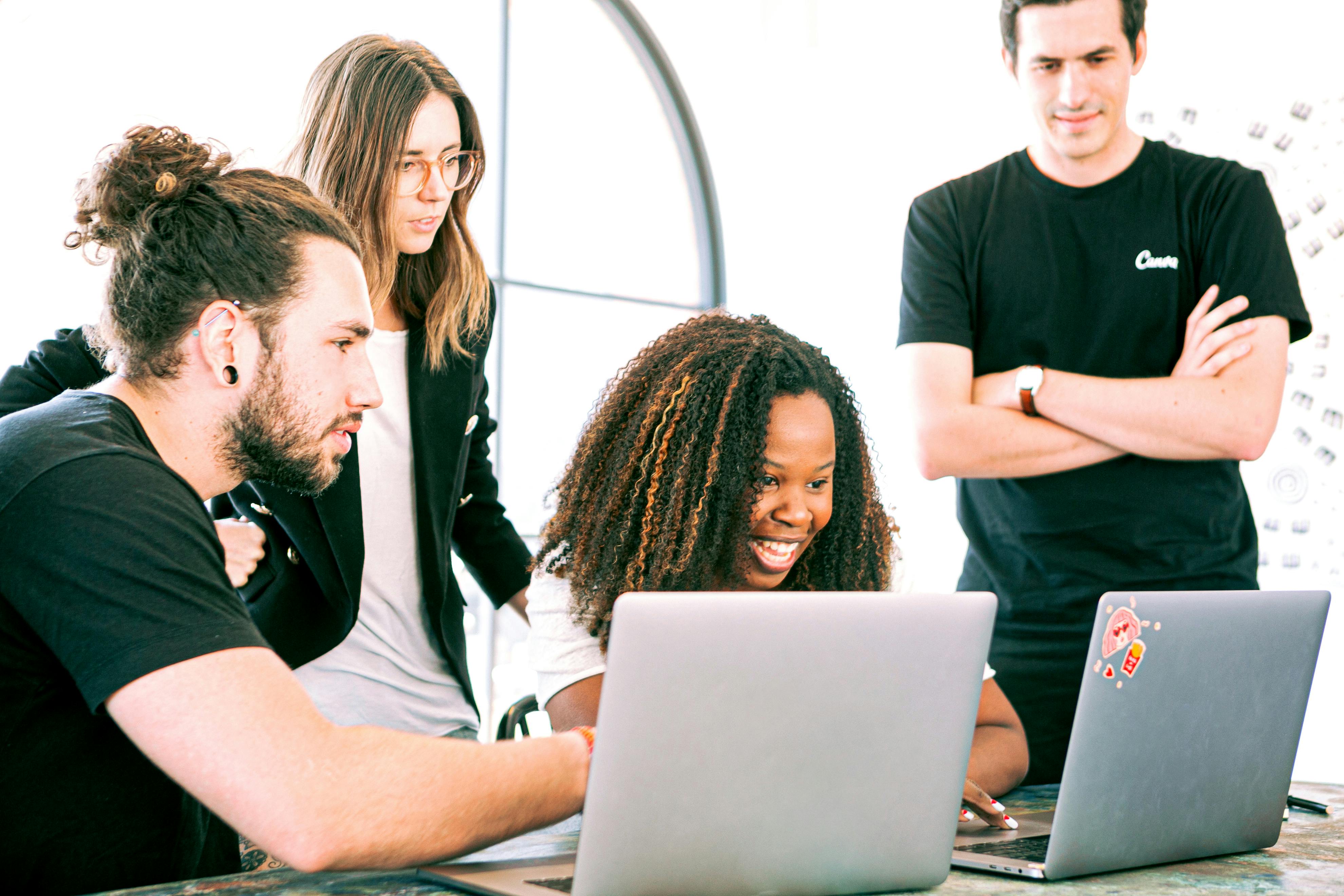 A group of young people looking together at a laptop