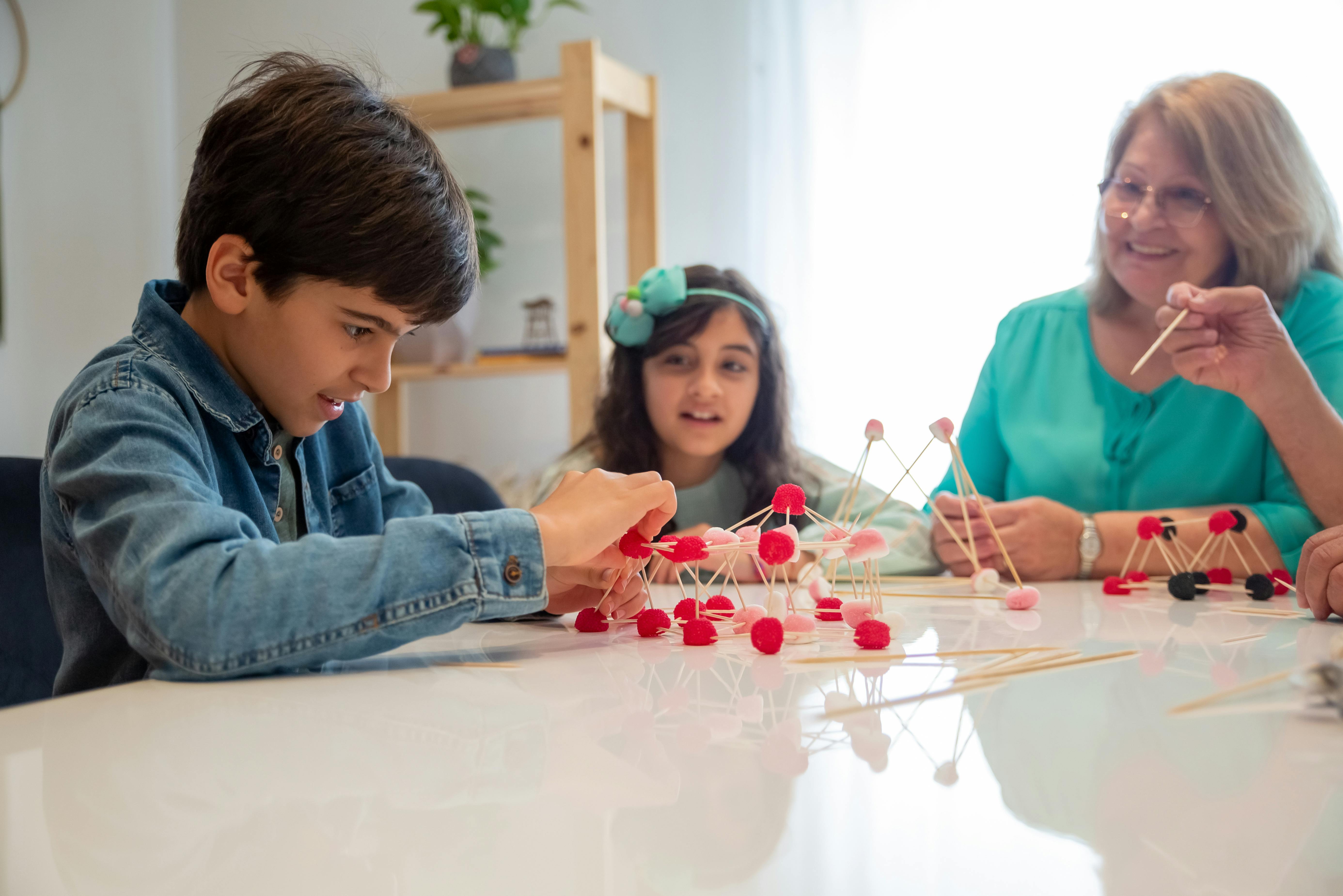 Children and older relative building a structure from toothpicks