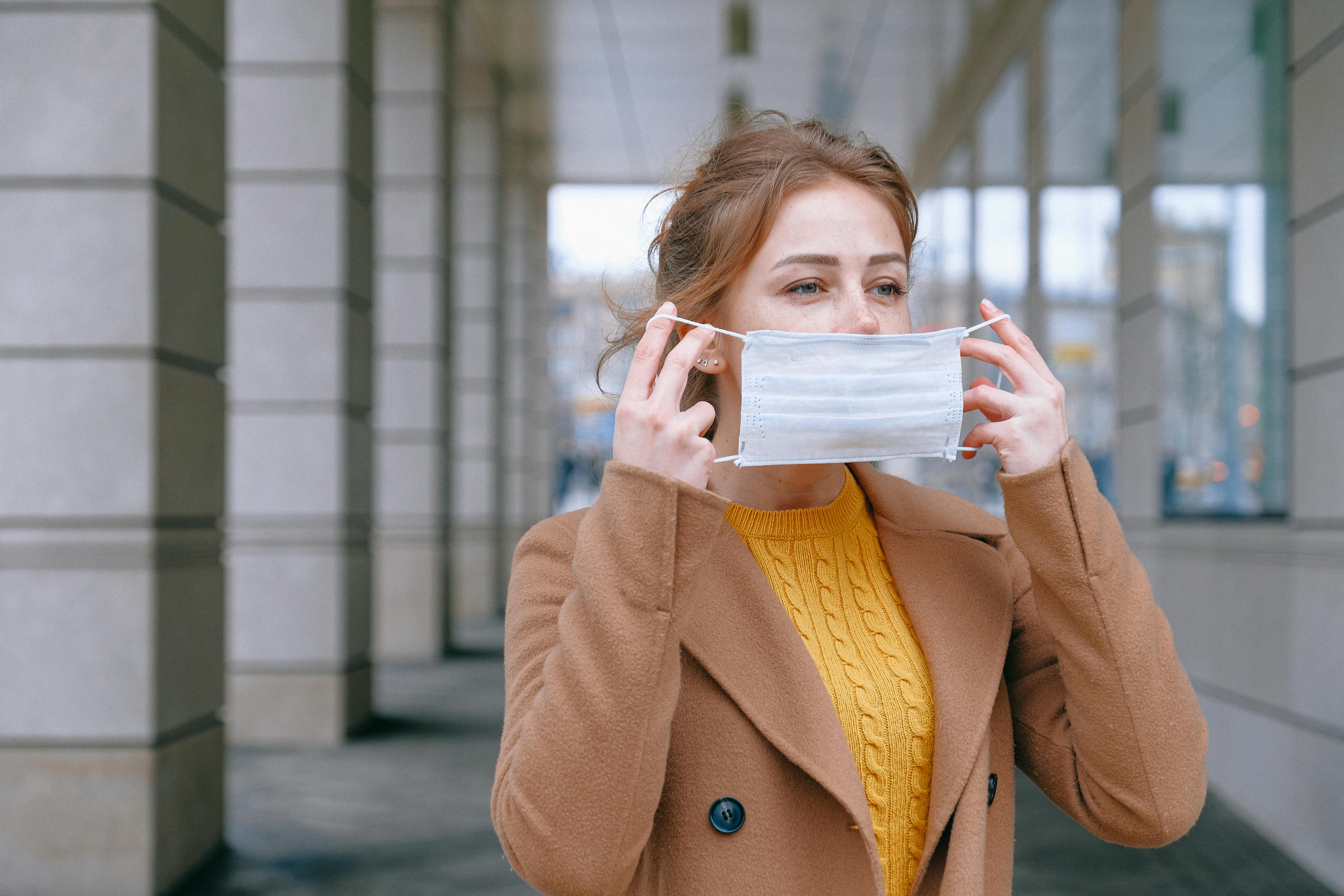Woman putting on face mask