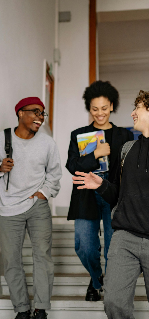 Three young people walking down stairs, laughing