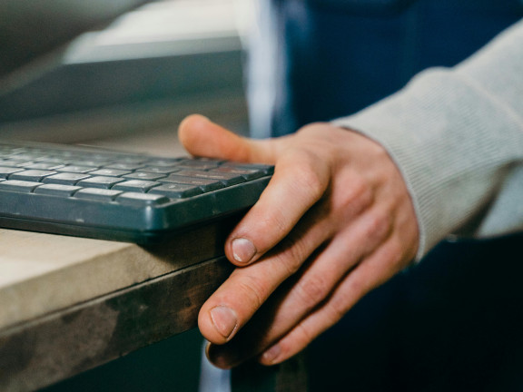 Man in a workshop holding a keyboard