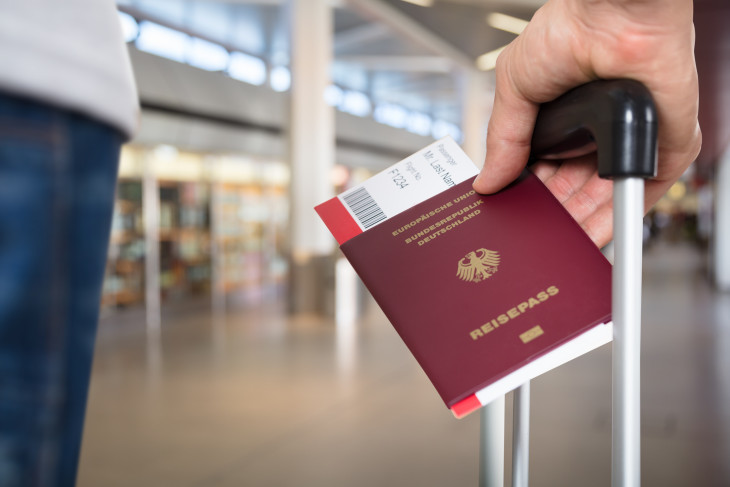 Person at airport with luggage and german passport