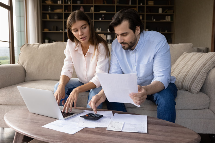 Man and woman on the couch doing finances