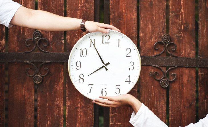 People holding up clock