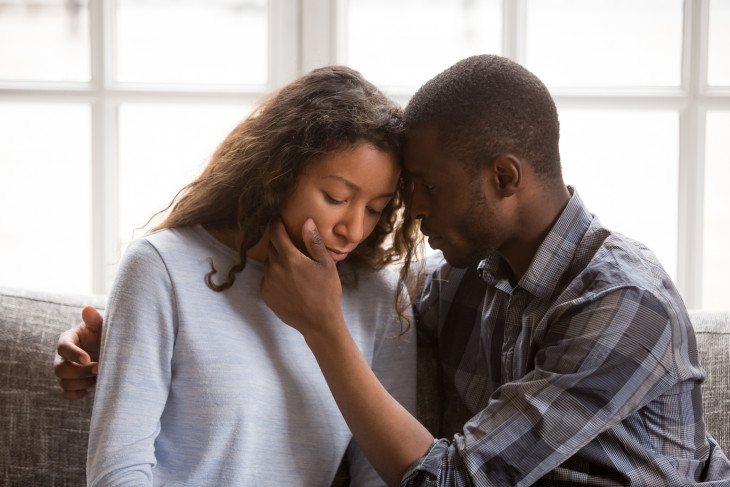 Loving African American husband touching wife face with tender