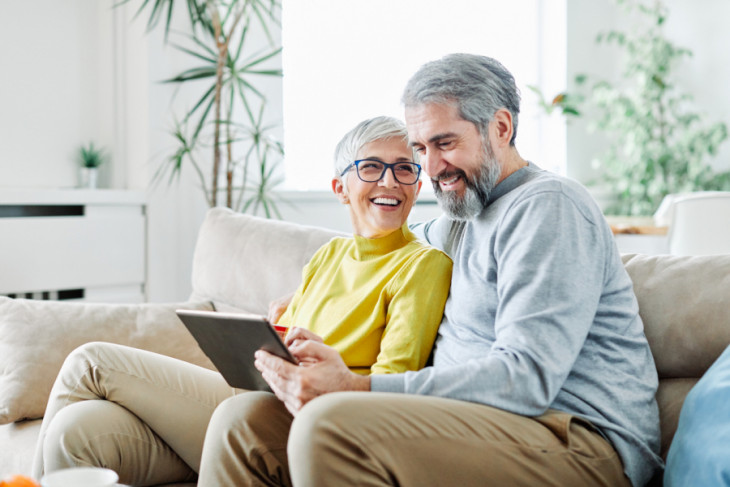 portrait of happy smiling senior couple using tablet at home