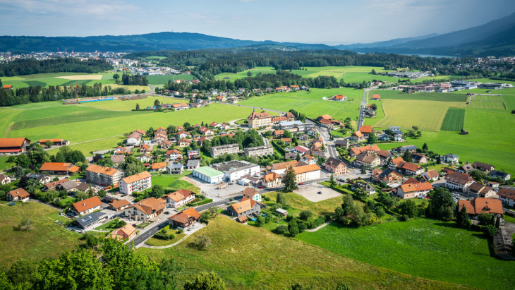 Aerial view of modern Epagny Gruyeres town and rural surroundings in La Gruyere Fribourg Switzerland