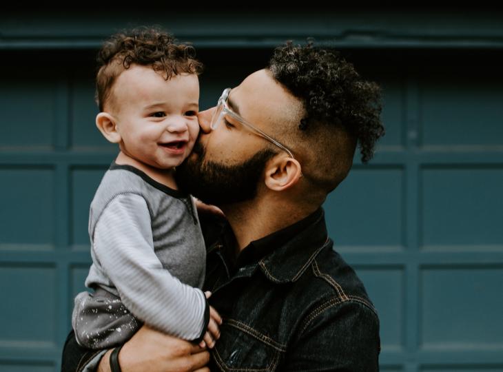 Father kissing child on cheek