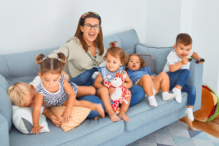 Woman sitting on couch with 5 children