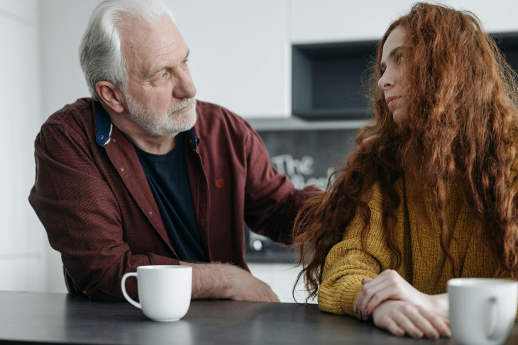 An older man consoling a young woman