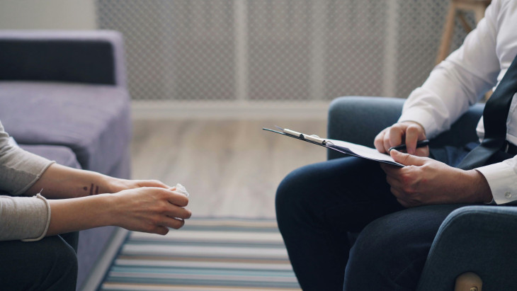 Two people at a counseling session, only hands are seen