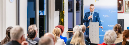 Speaker at a podium, audience sitting
